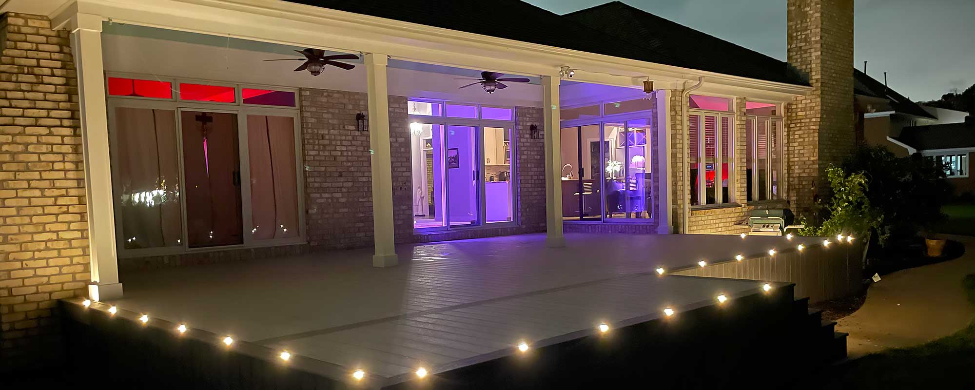 A modern outdoor deck at night features elegant lighting along its edges, showcasing professional craftsmanship and inviting ambiance, perfect for outdoor living and backyard transformation in Virginia Beach.| First In Decks and Fencing | Virginia Beach Deck Builders