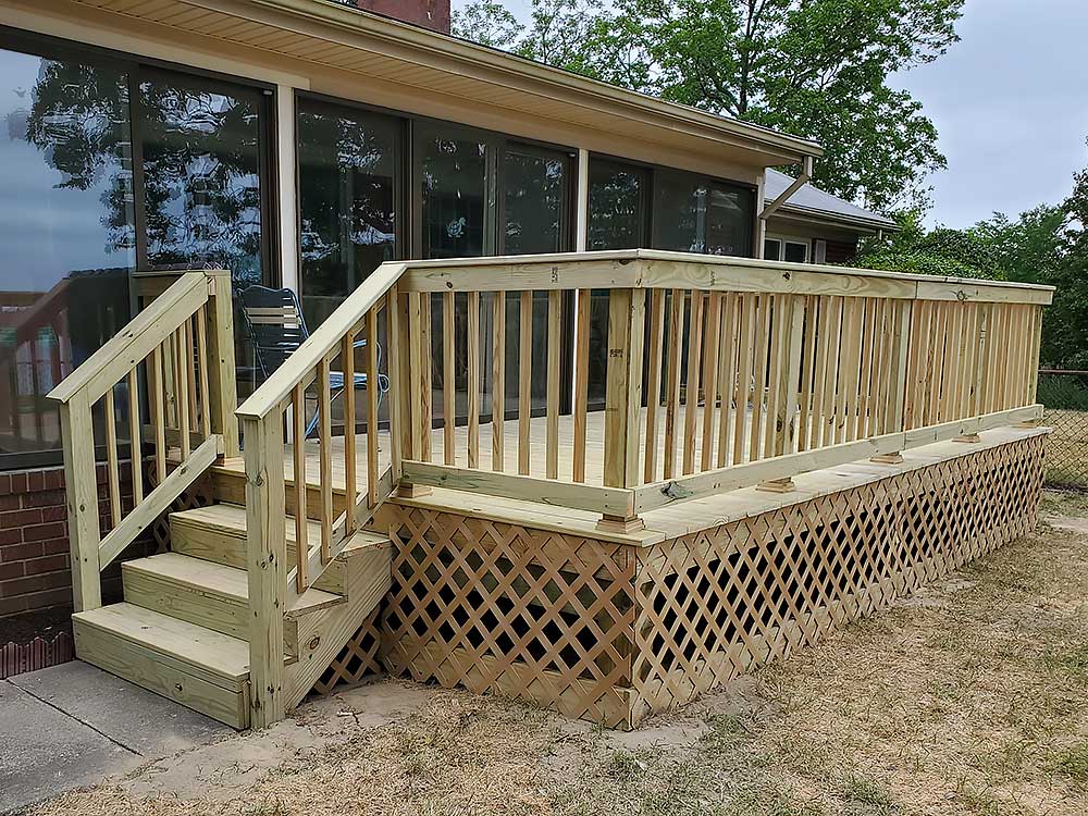 Lumber-deck-1 Pressure treated lumber deck with stairs and lattice skirting, offering a durable and attractive outdoor living space.