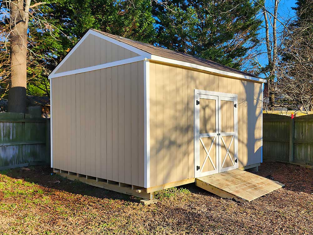 Custom storage shed built by First in Decks and Fencing, featuring durable materials and a sturdy ramp for easy access.